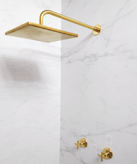 Gold shower head and fixtures on a marble wall