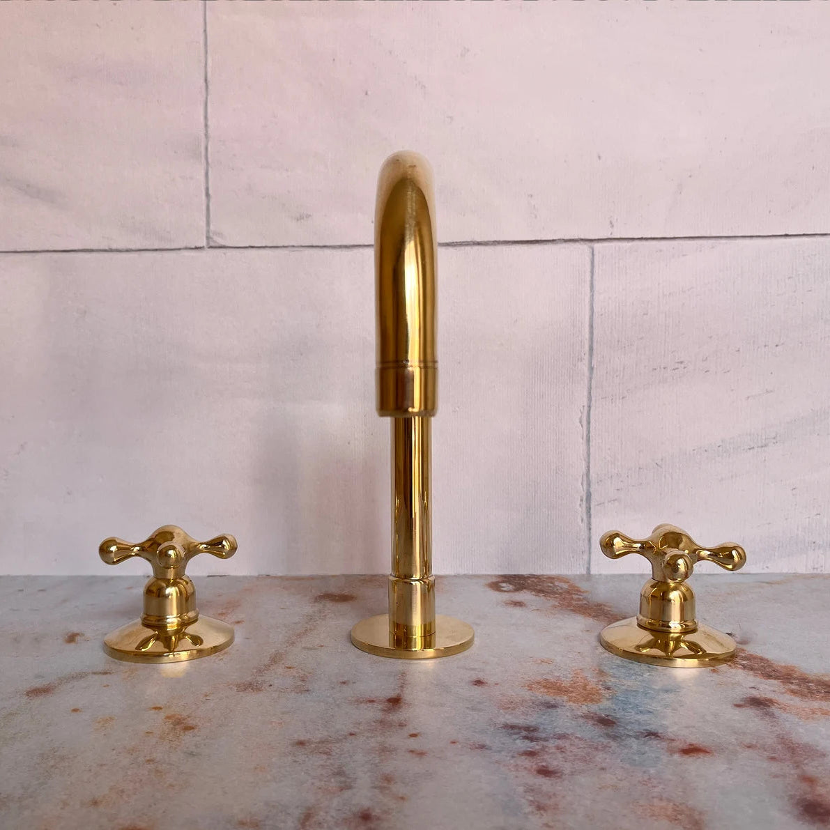 A set of unlacquered brass bathroom faucets 