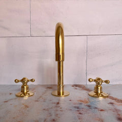 A set of unlacquered brass bathroom faucets 
