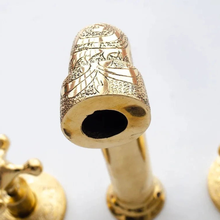 Gold faucet handles on a white background