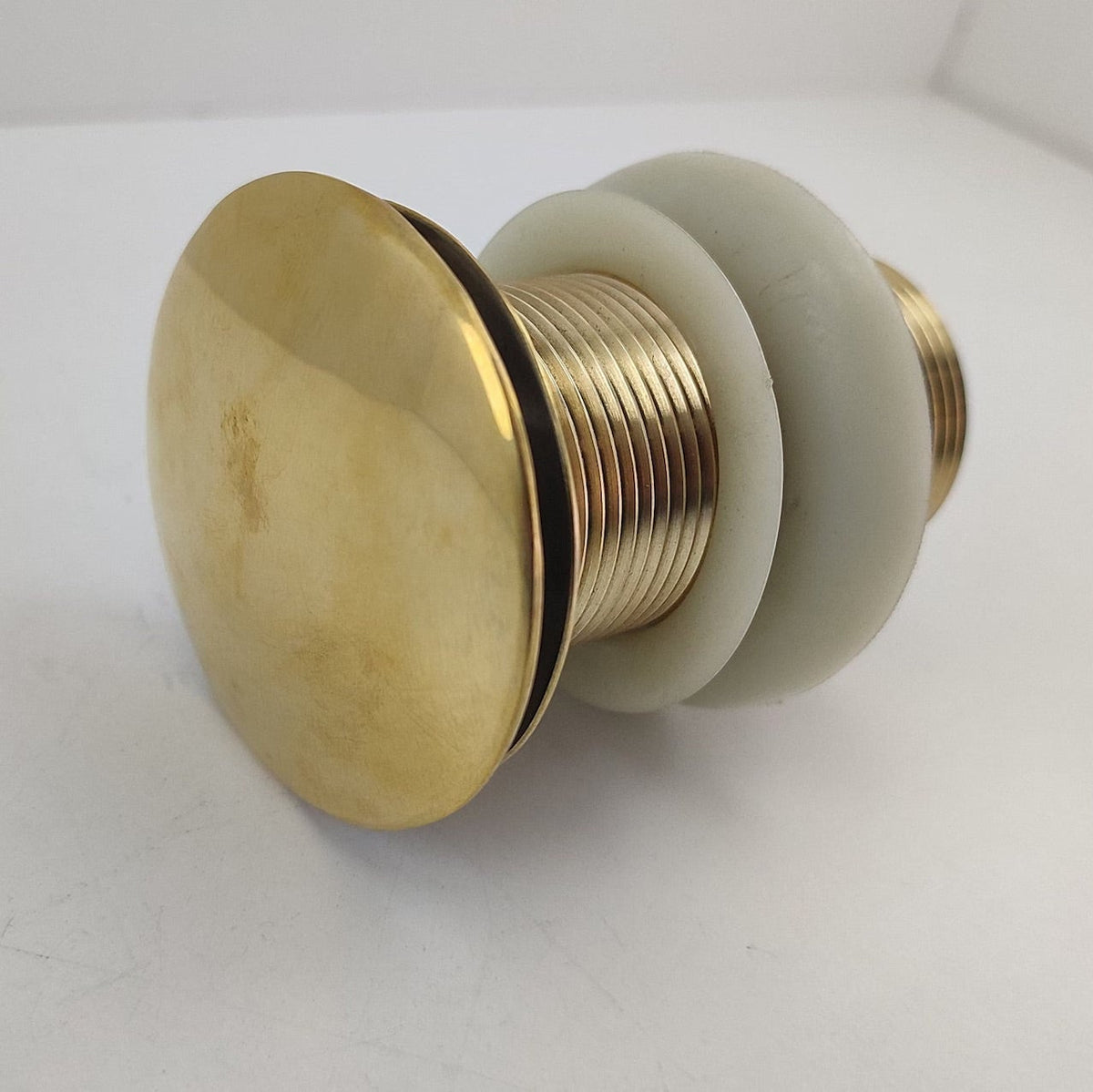A brass bathroom sink pop-up drain
